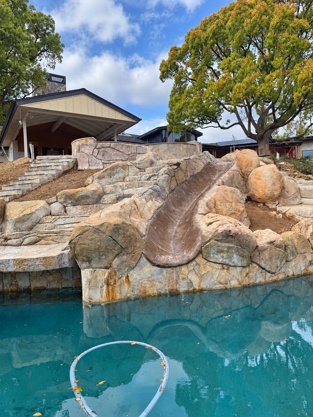 The slide's run, wrapped in sculpted boulders