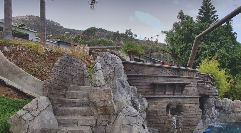A sculpted rock staircase climbs to the deck
